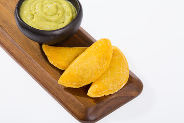 Colombian empanada with avocado sauce - on the white background.traditional colombian food
