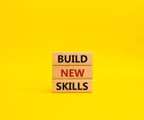 Build New skills symbol. Concept word Build New skills on wooden blocks. Beautiful yellow background. Business and Build New skills concept. Copy space