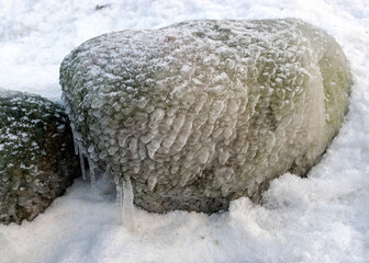 different ice formations on rocks on the seashore, ice texture, wind, water and ice working together