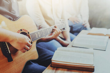 Christian young man group are playing guitar and sings a song from a Christian hymn book and the...