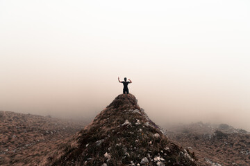 silhouette of a person on the top of a mountain