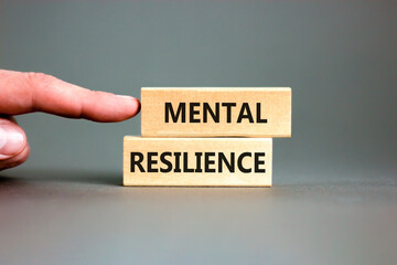 Mental resilience symbol. Concept word Mental resilience typed on wooden blocks. Beautiful grey table grey background. Doctor hand. Business psychological and mental resilience concept. Copy space.