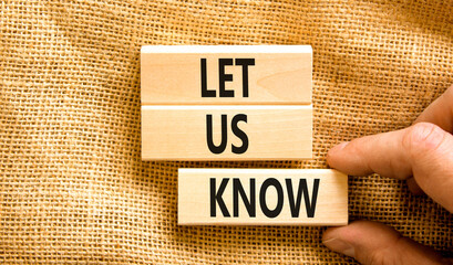 Let us know symbol. Concept words Let us know on wooden blocks on a beautiful canvas table canvas background. Businessman hand. Business and let us know concept. Copy space.