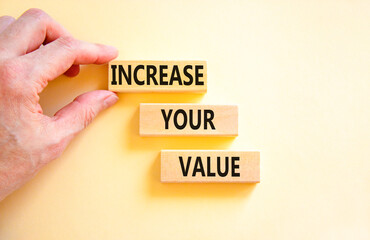 Increase your value symbol. Concept words Increase your value on wooden blocks on a beautiful white table white background. Businessman hand. Business increase your value concept. Copy space.