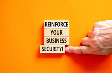 Reinforce your business security symbol. Concept word Reinforce your business security on blocks. Beautiful orange background. Business reinforce your business security concept. Copy space.