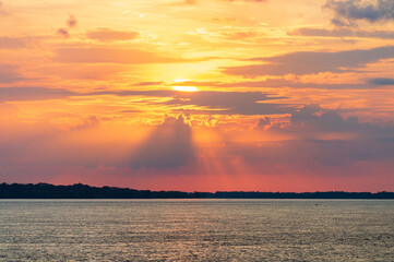 Amazing sunrise on the water of Amazon river in Brazil, nice soft warm light seeping through the clouds