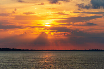 Amazing sunrise on the water of Amazon river in Brazil, nice soft warm light seeping through the clouds