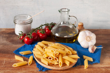 Ungekochte Penne Rigate mit Olivenöl, Knoblauch und Tomaten
