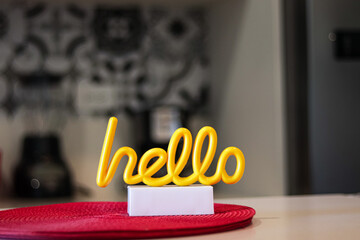 cute and stylish yellow Sign Reads Hello On A white an red Color Table In A airbnb apartment for tourist 