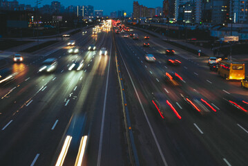 traffic shot from above over a busy road showing streaking trails of light of blurred cars 