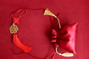 Chinese New Year, red silk pocket money bag and lucky decorative golden coins with Chinese blessing words means happiness, richness and good fortune, lucky item oriental with space copy