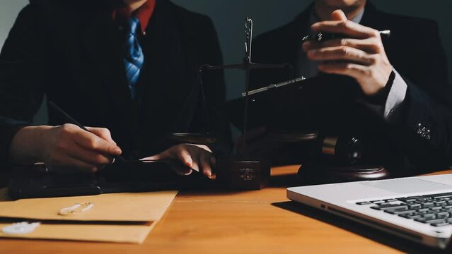 Business and lawyers discussing contract papers with brass scale on desk in office. Law, legal services, advice, justice and law concept picture with film grain effect