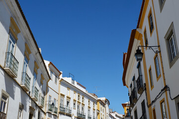 Fototapeta na wymiar Authentic facades of classical Portuguese buildings on streets of Evora, Portugal