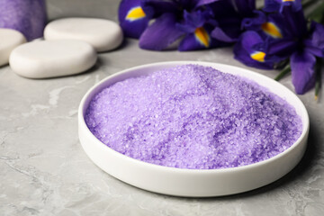Fototapeta na wymiar Plate with purple sea salt on grey marble table, closeup