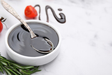 Organic balsamic vinegar and cooking ingredients on white marble table, closeup. Space for text