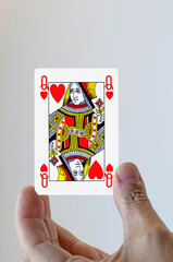 Hand with queen of hearts playing card