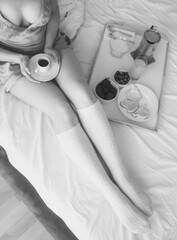 Young beautiful woman having romantic cozy breakfast at her bedroom 