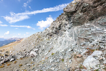 Pit face of abandonned asbestos surface mine, visible asbestos sinuosity, mix of chrysotile and tremolite, free fibers blowing with the wind, in natural environment, Queyras, French Alps