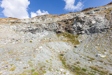 Pit face of abandonned asbestos surface mine, visible asbestos sinuosity, mix of chrysotile and tremolite, free fibers blowing with the wind, in natural environment, Queyras, French Alps