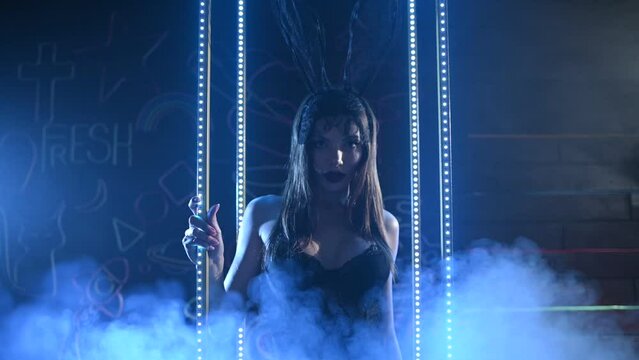 Gorgeous girl with rabbit mask posing in blue light. Smoke appears and goes out of focus, slowmotion x4