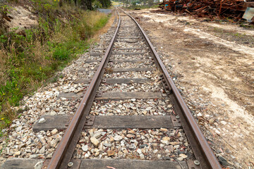 Fototapeta premium Photograph of old and rusty and out of service railway tracks with white stones and dead weeds