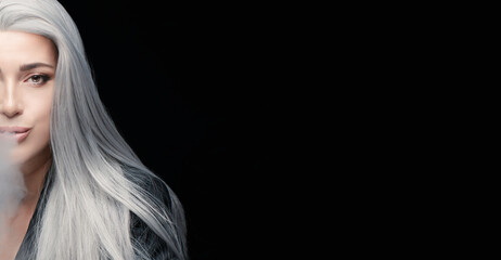 Cropped view of smoker woman blowing smoke. Silver haired woman isolated on black background with copy space