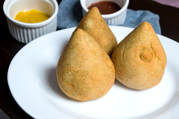 Three dumplings called coxinha inside a plate