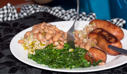 Image shows typical Brazilian meal that has the fork on top of the food being tasted