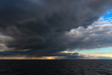Ocean with  of storm clouds with the sun's rays breaking through