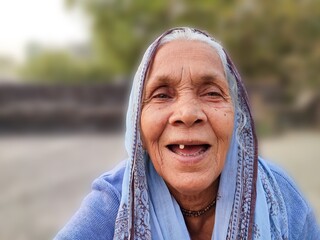 Old lady woman of the rural area of India, smiling, mother, nanny, and grandmother, people live in the village of the India and indian culture