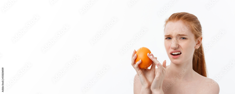 Wall mural Serious Cuacasian woman with orange on hand isolate over background. spa