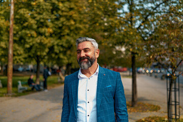 A senior businessman in a suit walking around the city after work