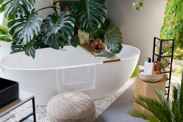 White bathroom with bathtub, green plants
