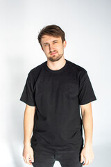 A young man is standing in a black T-shirt
