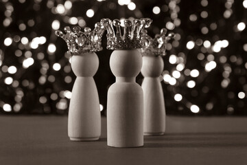 Happy Epiphany day concept. Three wise men figures with crowns on sepia glitter lights background.