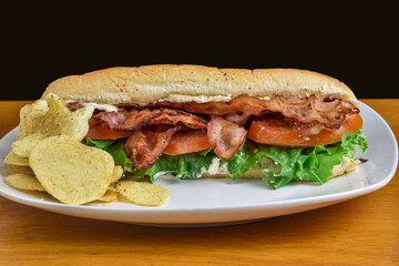 bacon lettuce and tomato sub with potato chips.