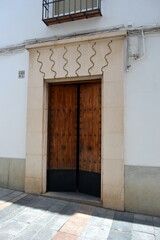 The beautiful exterior facade with a wooden door in the historic of Cordoba Spain