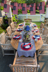 Festive Fourth of July party table set under garden pergola