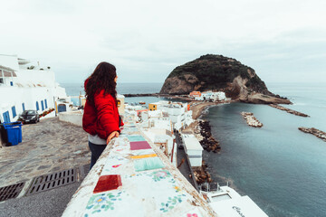 woman looking at views of the sea on the island - obrazy, fototapety, plakaty