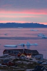 Colored houses in ilulissat town with icebergs in background