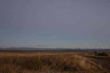 Road and fence against mountainous backdrop