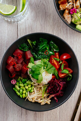 asian poke bowl with rice, vegetables and fresh tuna