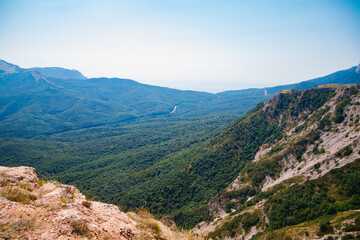 Mountain landscape in the warm season. Mountains and hills covered with forest, and blue sky. Beauty is in nature.