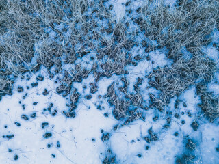 Aerial view of a frozen lake. Ice sheet background. Frozen grass on the lake. Ice background. Ice cover on a lake