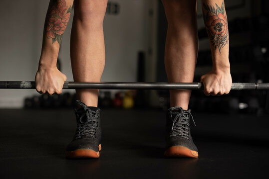 Athlete with tattoos lifting weights