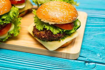 Delicious hamburgers on wooden table