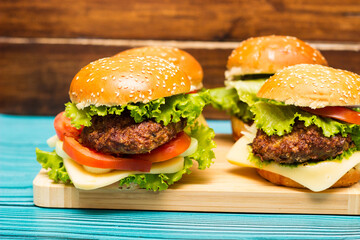 Delicious hamburgers on wooden table