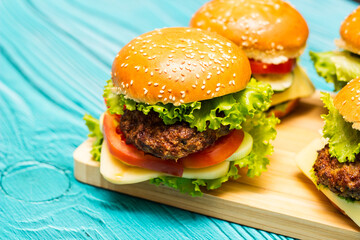 Delicious hamburgers on wooden table