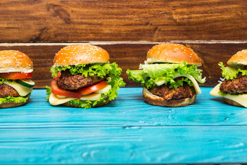 Delicious hamburgers on wooden table