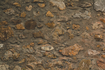 Horizontal stoned rock cobble stone wall with mortar for a textured background abstract material that is slightly dirty vintage and grunge non-uniform